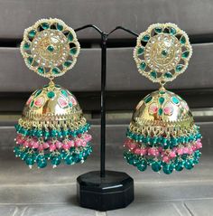 Big statement Jhumka earrings featuring a stunning turquoise and pink colour combo! The gold Kundan accents make these earrings look absolutely Royal and beautiful. They are sure to impress anyone paired with an ethnic outfit! Fusion Style Green Chandelier Earrings For Festive Occasions, Green Fusion Chandelier Earrings For Festive Occasions, Green Drop Earrings Jhumkas For Festivals, Green Drop Jhumkas For Festivals, Multicolor Bridal Earrings With Latkans, Multicolor Cutdana Earrings For Wedding, Multicolor Cutdana Wedding Earrings, Green Fusion Chandbalis For Festivals, Green Fusion Style Chandbalis For Festivals