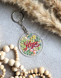 a keychain with the word hope on it next to some beads and feathers