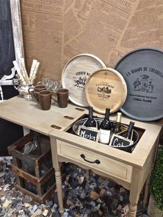 a table with two wine glasses on it and some bottles in the drawer next to it