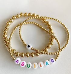 bracelet 1: plain 6mm bracelet 2: heart on 3mm beads bracelet 3: name on 3mm beads Choose ball finish & letter beads! will not tarnish! Cheap Birthday Name Bracelet With Heart Beads, Personalized Gold Jewelry With Colorful Beads, Gold Heart-shaped Name Bracelet With Letter Beads, Everyday Gold Name Bracelet With Colorful Beads, Everyday Yellow Gold Name Bracelet With Letter Beads, Collares Aesthetic, Silver Water, Gift Love, Letter Beads