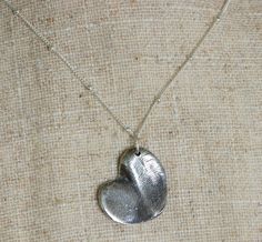 A heart shaped pendant is created by the impression of a soul mate, brother and sister, sister and sister, etc. A very precious gift for a loved one. The names and ages are stamped on the back of the heart. The heart is made from fine silver. The sterling silver chain is 16 inches. Please convo me if you would like a longer chain for a small additional cost. I will send you the mold material first...you create the mold and send it back to me. Then I will make the charm and send it back to you! A Heart-shaped Keepsake Jewelry For Father's Day, Silver Heart Print Jewelry Gift, Silver Heart Print Jewelry For Gift, Silver Heart Print Jewelry As Gift, Heart-shaped Engraved Necklaces For Father's Day, Engraved Heart Necklaces For Father's Day, Mother's Day Jewelry Gift With Heart Print, Father's Day Heart-shaped Engraved Necklaces, Nickel-free Heart Necklace For Personalized Gift