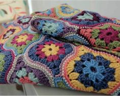 a multicolored crocheted blanket sitting on top of a table