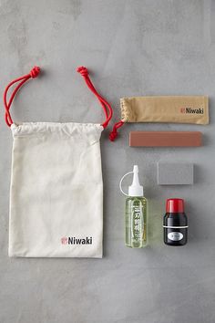 the contents of a travel kit laid out on top of a gray surface, including an empty bag