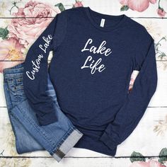 Perfect for a gift or for yourself to personalize by adding your favorite lake name to the sleeve.  Introducing our lightweight and stylish Lake Life Long Sleeve T-Shirt, crafted on the comfortable and premium Bella Canvas 3501 in the Heather Navy color. This is a unisex design so size down for a fitted look. Very soft and comfortable. Embrace the tranquil beauty of lake life with this soft and breathable long sleeve tee, perfect for those cool mornings and evenings by the water. Made from a blend of high-quality materials, this shirt offers the perfect balance of comfort and style, ensuring you stay cozy without feeling weighed down. Featuring a trendy lake-inspired design, whether you're lounging on the dock, enjoying a leisurely boat ride, or simply exploring the shoreline, this tee add Lake Life Shirt, Lake Names, Boat Ride, Lake Life, Stay Cozy, Cricut Ideas, Navy Color, Unisex Design, Long Sleeve Tee