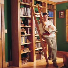 a man standing in front of a bookshelf with a ladder leaning against it