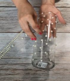 a person holding a glass with beads on it