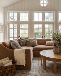 a living room filled with furniture and lots of windows