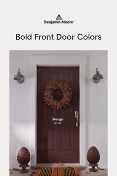 the front door is painted burgundy and has a wreath on it