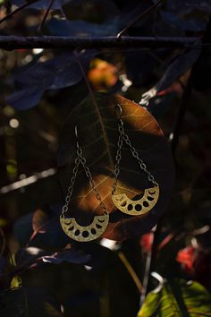 These handcrafted phases of the moon earrings have been inspired into creation by my love for and connection with the moon and her cyclical phases.  Solid raw brass arcs with the phases of the  moon cut out in them dangle from textured solid sterling silver chains and ear hooks.  I can make these earrings with either a regular ear hook or 16g hand hammered hoop ring that works well for stretched ears. See last pictures for stretched ear hoops and examples of the earrings with the stretched hoop Mystical Gold Moon Phase Earrings, Bohemian Crescent Moon Phase Jewelry, Crescent Sun And Moon Festival Jewelry, Festival Crescent Sun And Moon Jewelry, Festival Crescent Jewelry With Sun And Moon Design, Celestial Moon Phase Moon Earrings, Mystical Sun And Moon Brass Jewelry, Mystical Brass Jewelry With Sun And Moon Design, Half Moon Earrings With Moon Charm