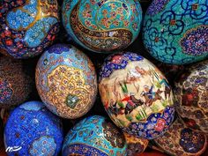 many different colored eggs are stacked on top of each other in a pile, with designs painted on them