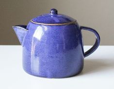 a blue ceramic teapot with a gold rim