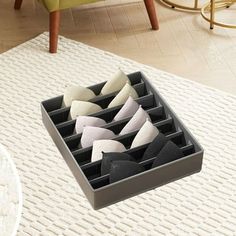 an open drawer on top of a rug in a living room with chairs and tables