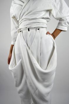 Made in FranceProduct description :- Very wide white pants,- High waist,- Invisible pockets and back darts,- Panels on the sides that attach to the belt or that can be left hanging,- Closed with a zip fly and a metal snap button.The Balmorra Pant is caracterized and formed delicately bu light, free and fluid curves. The pant recalls the inspirations of travel to which the Louise Marcaud brand attaches itself by adding its own touch of minimalism with fine and clean lines. Bold, lightweight trous Wide White Pants, Sarouel Pants, Unique Pants, Illustration Fashion Design, Clothing Details, Fashion Hacks Clothes, Mode Hijab, Pantalon Cargo, Pants Design