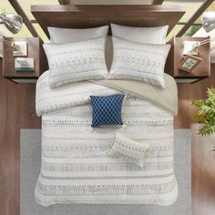 a bed with white and blue pillows on top of it