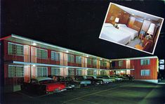 the motel is lit up at night with cars parked in front