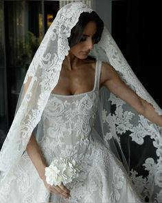 a woman in a wedding dress with a veil over her head