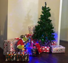 a christmas tree is surrounded by presents on the floor