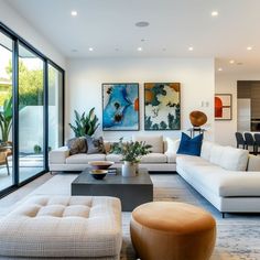 a living room filled with white furniture and lots of glass doors leading to an outside patio