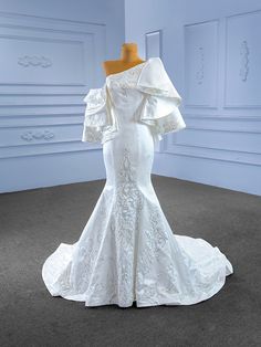 a white wedding dress on display in a room