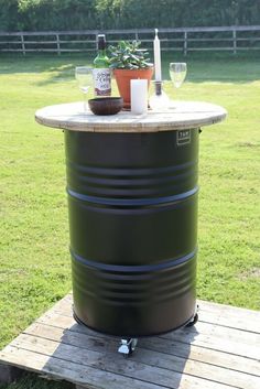 an outdoor bar with wine glasses and bottles on it in the middle of a grassy area