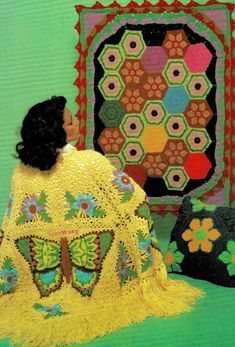 a woman sitting next to two crocheted bags and a butterfly afghan on a green background