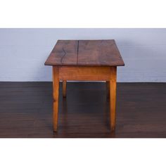 a small wooden table sitting on top of a hard wood floor next to a wall