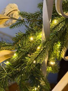 a close up of a christmas tree with lights on it and scissors hanging from the branches