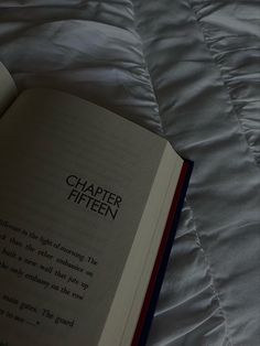 an open book sitting on top of a bed