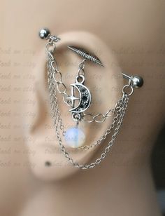 a close up of a mannequin head with chains and moon charms on it