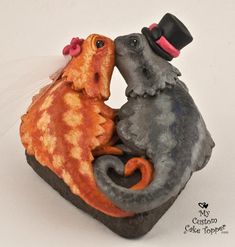 two figurines in the shape of mice kissing on top of a piece of stone