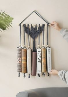 a wall hanging with books on it and a house shaped like a bookmark attached to the wall