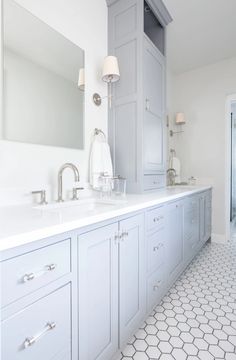 a white bathroom with two sinks and mirrors