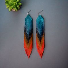 Add a vibrant touch to your outfit with these Boho Bead Ombre Fringe Earrings. Featuring a stunning blue and orange gradient, these handmade statement dangles are perfect for any bohemian style lover. The intricate beadwork creates a beautiful ombre effect, making these earrings a unique and eye-catching accessory. Ideal as a gift for her, these colorful ethnic earrings bring a pop of color and elegance to any ensemble. Elevate your jewelry collection with these exquisite, artisan-crafted fringe Ombre Fringe Earrings, Bohemian Jewelry Gift, Orange Gradient, Beaded Earrings Patterns, Ethnic Earrings, Beading Projects, Earrings Blue, Earring Patterns, Boho Stil