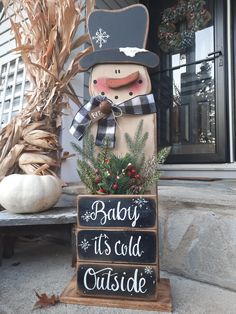 a wooden snowman sitting on top of a sign