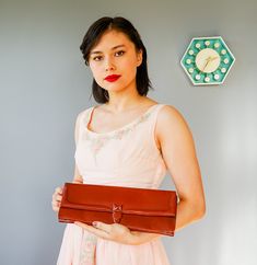 "DESCRIPTION * Vintage purse from 1940s-early 1950s * envelope clutch style: oblong shape, front flap, to be carried \"clutched\" in the hand, strapless * made with reddish-brown leather. I believe it is genuine leather considering its feels, smells, discoloration spots, and texture but there is no tag to confirm this * insert closure * lined with bronze satin fabric * has three small pockets, the largest one has a zippered closure * tag reads \"Lennox\" CONDITION * Minor scratches and discolora Vintage Evening Bag For Vintage Events, Vintage Envelope Bag For Everyday Use, Retro Brown Clutch For Evening, Vintage Evening Bag For Events, Retro Clutch Bag For Vintage Events, Retro Clutch For Vintage Events, Vintage Brown Evening Bag, Vintage Brown Clutch For Party, Brown Retro Clutch For Formal Occasions