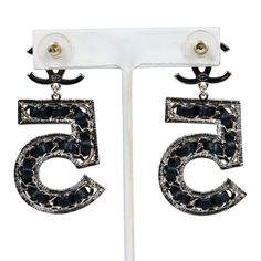 These No 5 drop earrings are in light gold tone metal and feature large N0 5's dangling off small crystal CCs with post back earring closure. Origin: FranceCondition: New and never wornAccompanied by: Chanel box, Chanel pouch, retail UPC and ribbonMeasurements: 2.25" height x 1" width Chanel Pouch, Chanel Box, Black Earrings Dangle, Drop Dangle Earrings, Earrings Black, Metal Earrings, No 5, Fendi Bags, Burberry Bag