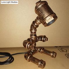 an old brass lamp is turned into a tripod light fixture with two hoses connected to it