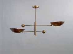 a chandelier hanging from the ceiling with three bowls on each one and two lights above it