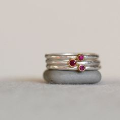 Set of 3 ruby 18k gold and sterling silver stacking rings. Red rubies wrapped in rich 18k yellow gold on sterling silver bands. Two of the rings are set with 2mm rubies, and the third is set with a 2.5mm ruby. The rubies sit together like sweet little berries. The 1.6mm bands have been given a hammered texture. Details: Bands - 1.6mm sterling silver Rubies - 2mm and 2.5mm Texture - hammered Finish - Choose your desired finish at checkout...shown with a brushed satin finish. **Also available in a Stackable Ruby Ring Jewelry, Fine Jewelry Ruby Stackable Rings, Fine Jewelry Stackable Ruby Rings, Stackable Ruby Ring In Fine Jewelry Style, Stackable Yellow Gold Ruby Ring In Sterling Silver, Sterling Silver Stackable Ruby Ring, Stackable Ruby Ring In Yellow Gold And Sterling Silver, Stackable Sterling Silver Ruby Ring For Anniversary, Stackable Sterling Silver Ruby Ring