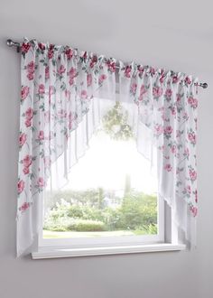 the window is decorated with pink flowers and white curtains