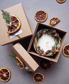 two boxes with orange slices and a candle inside