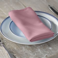 a pink napkin sits on top of a plate