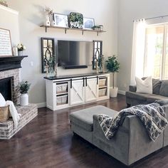 a living room filled with furniture and a flat screen tv on top of a fireplace