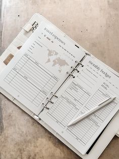 an open planner and pen sitting on top of a table