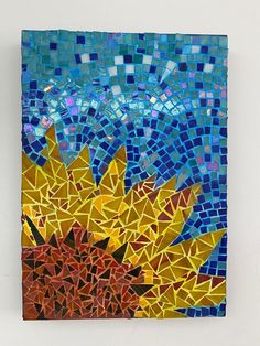 a piece of art that looks like a sunflower with blue and yellow tiles on it