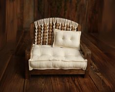 a wooden chair with two pillows on top of it and wood flooring in the background