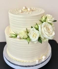 a white wedding cake with flowers and pearls