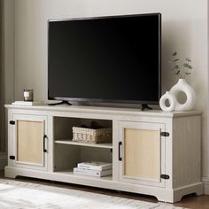 a flat screen tv sitting on top of a white entertainment center