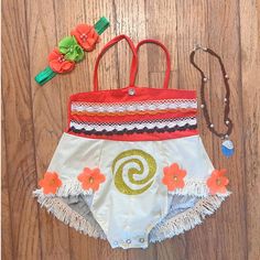 a red and white bathing suit with flowers on the bottom is next to an orange flower headband