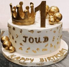 a birthday cake with gold decorations and a number one on top